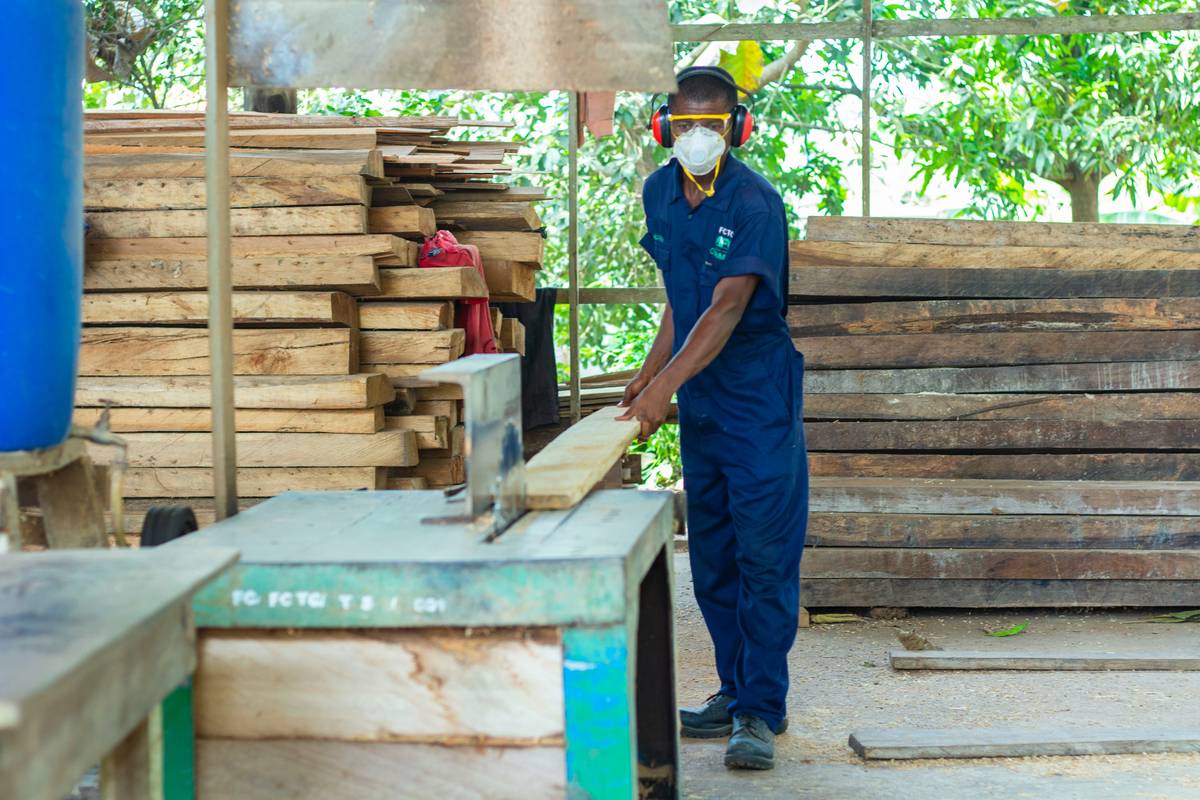 Worker wearing a mask for construction dust while sanding drywall in a home renovation setting