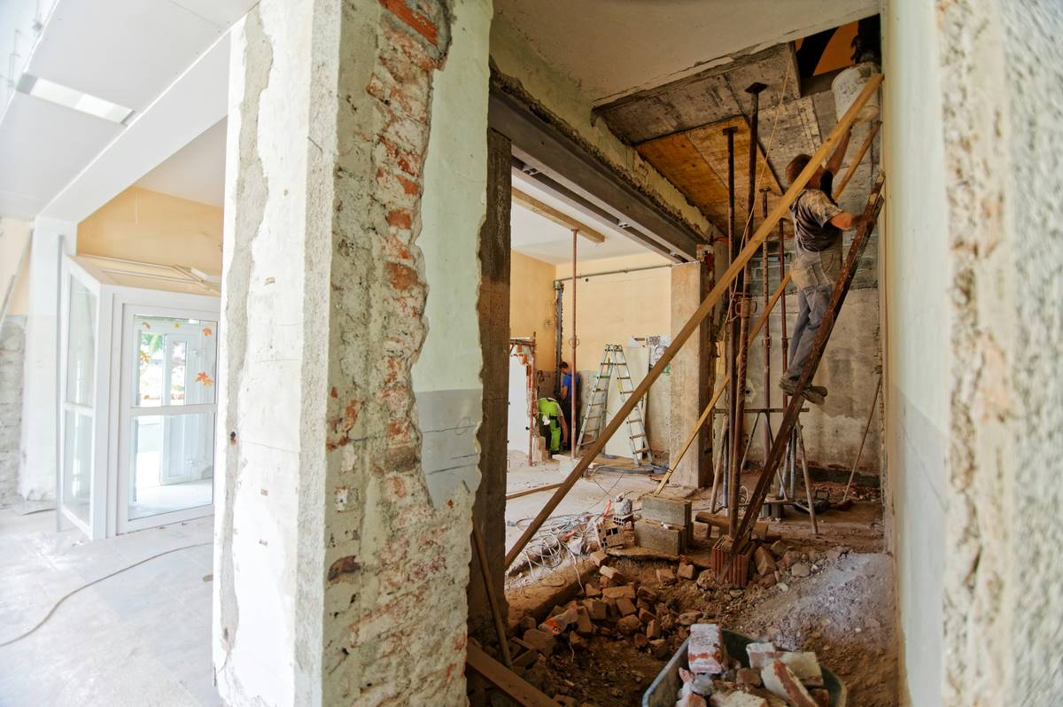 Worker wearing a proper N95 mask for dust protection while sanding drywall